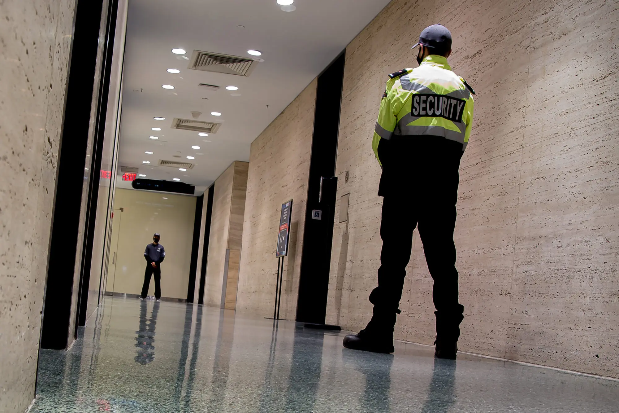 A low-angle shot of security guards patrolling inside a commercial building.